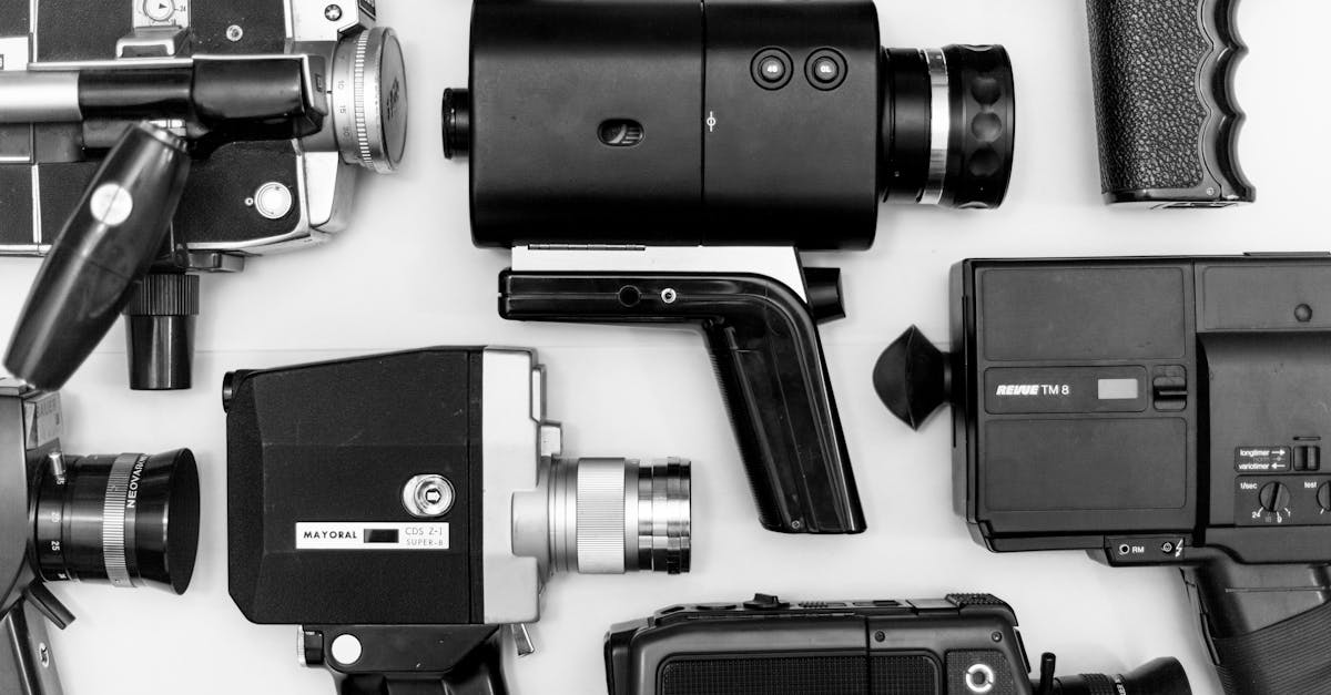 Flat lay of assorted vintage video cameras in black and white photography.