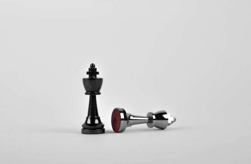 Close-up of chess king piece standing with a fallen piece symbolizing strategy and victory.